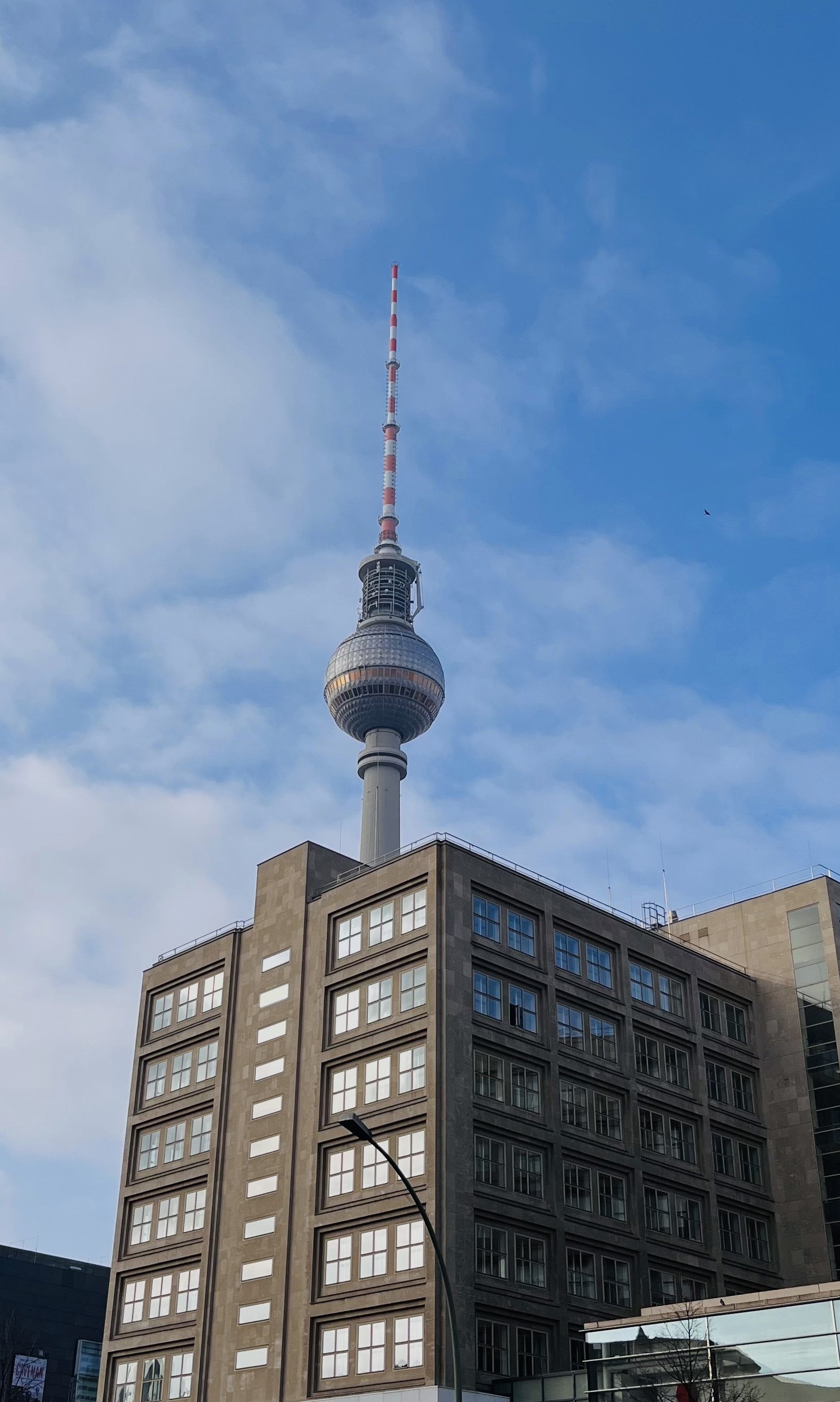 Ein Hochhaus, hinter dem der Berliner Fernsehturm hervorlugt