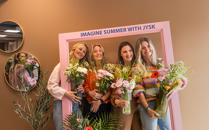 Vier vrouwen staand in een kader met bloemen
