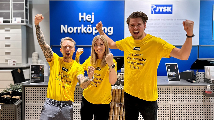 Three Swedish employees with yellow shirts that have the statement to cheer for the Swedish team i Paris. 