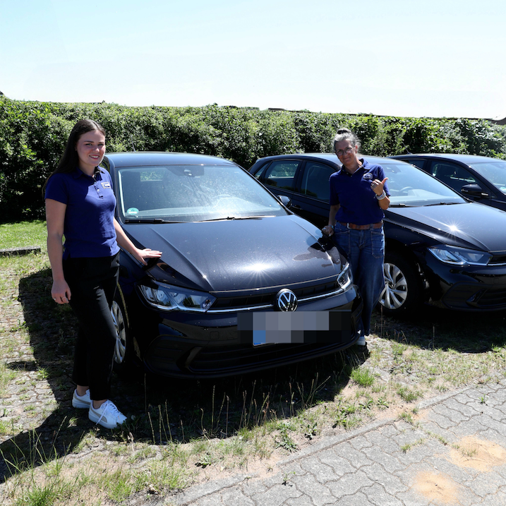 Zwei Frauen stehen links und rechts neben einem VW Polo. Sie lächeln in die Kamera