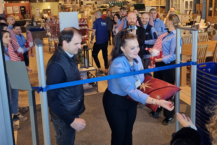Store Manager Vittoria asks a customer for help with cutting the ribbon and opening the new store.