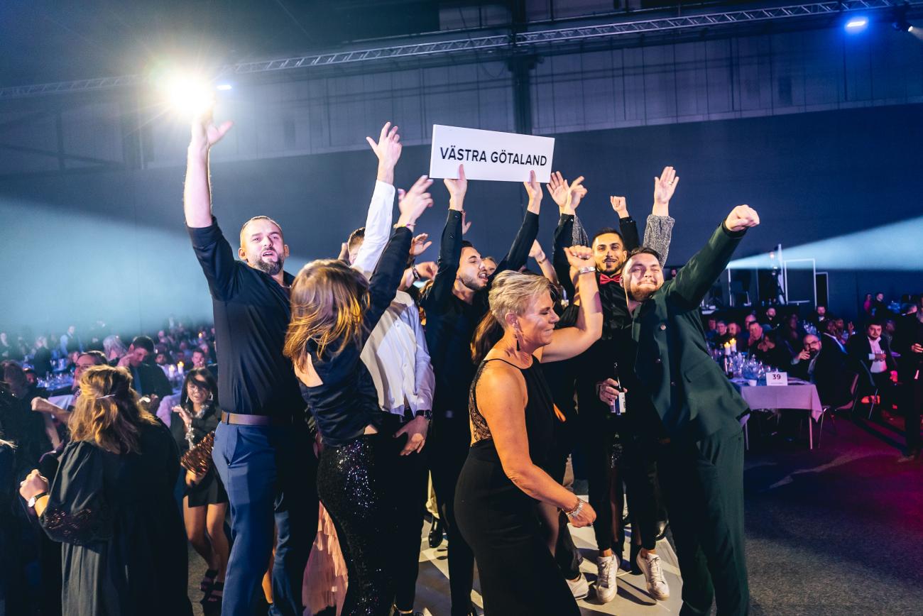 En grupp JYSK-medarbetare dansar på scenen mitt i lokalen. Foto: Joakim Thörne.