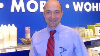 Man in a blue shirt and tie smiling