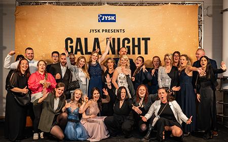 Ein JYSK-Team vor der Fotowand