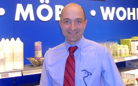 Man in a blue shirt and tie smiling